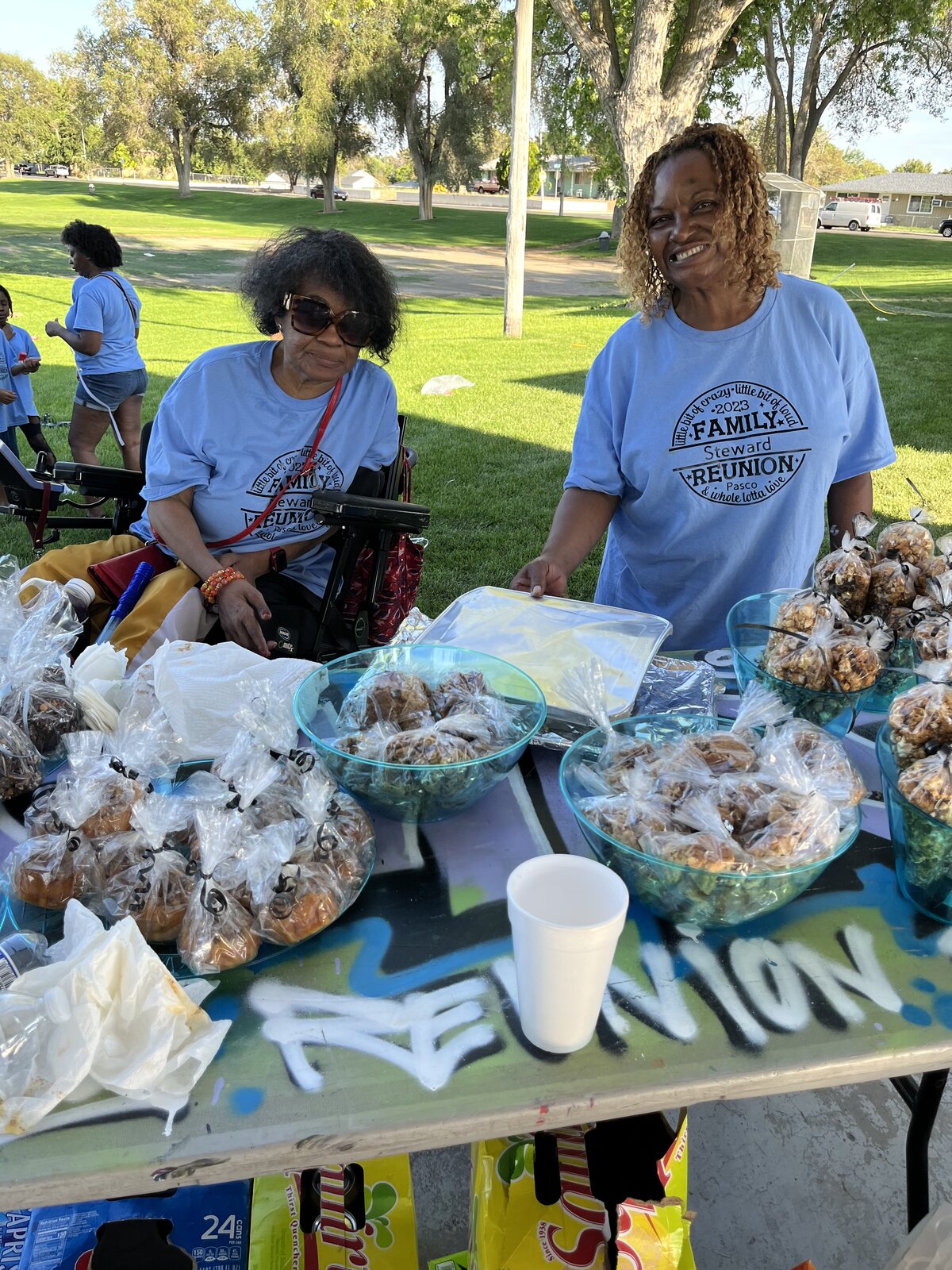 Steward family members at the cookout table with treats and snacks at the park